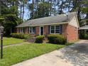 A cozy brick home featuring a covered parking area and lush, green landscaping at 520 Charlotte Ave, Rocky Mount, NC 27804