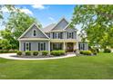 Charming two-story home featuring gray siding, black shutters, manicured landscaping, and a welcoming front porch at 532 Joe Collins Rd, Lillington, NC 27546