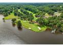Scenic aerial view of a golf course along a lakefront with lush green fairways and pristine sand bunkers at 6102 Burning Tree Cir, Sanford, NC 27332