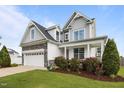Attractive home featuring a stone-accented garage, inviting front porch, and well-maintained landscaping at 81 Dot Ct, Fuquay Varina, NC 27526