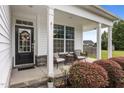Cozy front porch with comfortable seating, a stylish front door, and vibrant landscaping at 81 Dot Ct, Fuquay Varina, NC 27526
