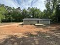 Exterior view of the home with a small deck and freshly painted siding, all set on an unfinished lot at 8505 Ray Rd, Raleigh, NC 27613