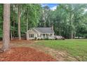 Picturesque single-story home surrounded by lush greenery and mature trees in a tranquil setting at 8801 Valley Hill Ct, Apex, NC 27539