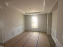 An empty room with crown molding, paneled walls, and a large window at 10 Slippery Elm Rd, Youngsville, NC 27596