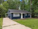 Inviting single-story home with a well-maintained lawn, paved driveway, and cozy front porch entrance at 105 Hanna St, Carrboro, NC 27510