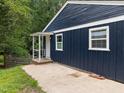 Side view of this blue home shows a small porch and a concrete patio area at 105 Hanna St, Carrboro, NC 27510