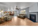 Open-concept living room featuring hardwood floors, fireplace, ceiling fan and view into the kitchen and dining area at 119 Tadworth Ct, Mebane, NC 27302