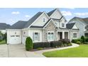 Attractive home with a spacious driveway and well-maintained landscaping with a partial garage view at 121 Hardy Oaks Way, Holly Springs, NC 27540