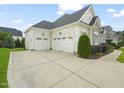 Three car garage with ample driveway space and manicured landscaping at 121 Hardy Oaks Way, Holly Springs, NC 27540