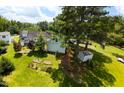Aerial view showcasing a spacious backyard, lush greenery, and detached garage at 2016 Cypress Ct, Clayton, NC 27520