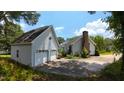 Exterior view of a home featuring a detached garage, chimney, and spacious driveway at 2016 Cypress Ct, Clayton, NC 27520