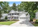 Charming two-story white home with black shutters, red door and attached two-car garage at 2422 Castleburg Dr, Apex, NC 27523