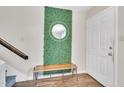 Welcoming foyer with decorative mirror, bench, and light hardwood flooring at 2602 Hitchcock Dr, Durham, NC 27705