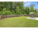 Spacious backyard featuring a privacy fence, lush green lawn and a seating area at 267 Dando St, Garner, NC 27529