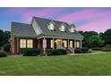 Charming brick home with a welcoming front porch, well-maintained landscaping, and a beautifully manicured lawn at 280 Phillips Rd, Selma, NC 27576