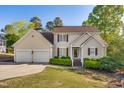 Inviting home with a two-car garage, manicured lawn, and charming front porch at 306 Neuse Ridge Dr, Clayton, NC 27527