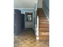 Entryway with hardwood floors, wooden staircase, blue accent wall, and framed mirror at 3129 Skycrest Dr, Raleigh, NC 27604
