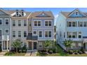 Charming two-story townhome featuring a well-manicured lawn and stylish architectural details at 319 Great Northern Station Sta, Apex, NC 27502