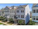 Charming two-story townhome featuring a well-manicured lawn and stylish architectural details at 319 Great Northern Station Sta, Apex, NC 27502
