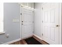 Neutral entryway features a white door and a dark rug on a hardwood floor at 320 Gilman Ln # 106, Raleigh, NC 27610