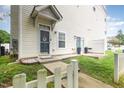 View of the home's front door, and the side yard which has a patio and a grill at 320 Gilman Ln # 106, Raleigh, NC 27610