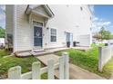 A view of the home's front door, and the side yard which has a patio and a grill at 320 Gilman Ln # 106, Raleigh, NC 27610