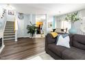Open-concept living space showcasing hardwood floors, a staircase, and a view into the modern kitchen at 320 Gilman Ln # 106, Raleigh, NC 27610