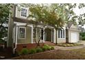 Inviting home entrance with covered porch, lush landscaping, and a well-manicured lawn at 3209 Leebrook Rd, Raleigh, NC 27616