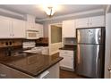 Well-lit kitchen with white cabinetry, stainless steel appliances, and beautiful countertop finishes at 3209 Leebrook Rd, Raleigh, NC 27616