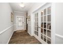 Bright foyer features wood floors, white trim, and glass french doors to the office at 512 Courtship Cv, Durham, NC 27703