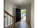 View through an open black front door with wood-look floors and staircase nearby at 545 Writers Way, Morrisville, NC 27560