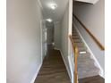 Hallway with wood floors leading to carpeted stairs and rooms with neutral paint at 545 Writers Way, Morrisville, NC 27560