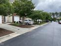 Exterior view of the house showing the neighborhood street, sidewalk, and neighboring houses at 545 Writers Way, Morrisville, NC 27560
