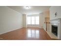 Bright living room with a fireplace, large windows and gleaming hardwood floors at 5916 Longeria Ct, Raleigh, NC 27612
