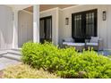 Inviting front porch with bluestone pavers and seating area with stylish chairs and pillows at 6900 Staghorn Ln, Raleigh, NC 27615