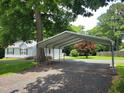 View of a metal carport beside the home and a spacious gravel parking area at 78 Phil Johnson Rd, Sanford, NC 27330