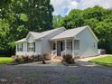 Charming single-story home with a metal roof, landscaped yard, and welcoming front porch at 78 Phil Johnson Rd, Sanford, NC 27330