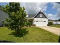 Charming home with a lush green lawn, flower beds, and a tree in the yard at 83 Mariners Point Way, Garner, NC 27529