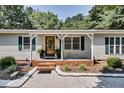 Inviting porch with covered entryway and a decorative wooden door surrounded by lush shrubbery at 835 Pearleman Teague Rd, Siler City, NC 27344