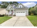 Inviting gray home with a well-kept lawn, covered porch, and convenient two-car garage, perfect for Gathering living at 853 Bluffcreek Dr, Fuquay Varina, NC 27526