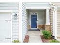 Welcoming front entryway with a blue door, stone accents, and modern lighting fixture at 9 Moss Side Ter, Durham, NC 27703