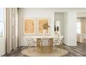 Bright dining room with a round wooden table, six chairs, and modern art prints at 1032 Red Finch Way, Angier, NC 27501