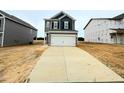 Stylish two-story home with a wide driveway leading to a two-car garage and grey horizontal siding at 120 Bruce Dr, Dunn, NC 28334