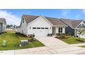 Inviting exterior featuring a manicured lawn, white siding, and an attached garage with lush plantings at 1319 Richfield Oaks Dr, Fuquay Varina, NC 27526
