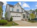 Charming two-story home with white siding, an attached garage, and a beautifully landscaped front yard at 140 Big Barn Dr, Wendell, NC 27591