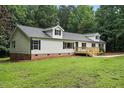 View of a home's exterior with dormer windows, a front deck, and lush green landscaping at 160 Deer Tracks Dr, Wendell, NC 27591