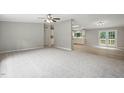A spacious living room featuring plush carpeting, fresh neutral paint, and seamless flow into the kitchen at 160 Deer Tracks Dr, Wendell, NC 27591