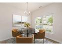 Bright dining area featuring a chandelier, artwork, and natural light from the large window at 1642 Holly Grove Way, Durham, NC 27713