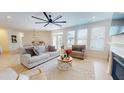 Bright living room featuring a ceiling fan, hardwood floors, and many windows at 1720 Pinecliff Ct, Fuquay Varina, NC 27526