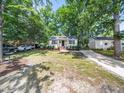 Inviting exterior of a well-maintained home with mature trees and a long driveway on a sunny day at 1825 Watkins St, Raleigh, NC 27604